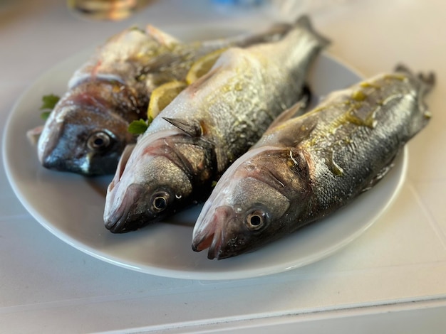 プレートにレモンをつけたグリルの魚魚市場のクロアチアの魚