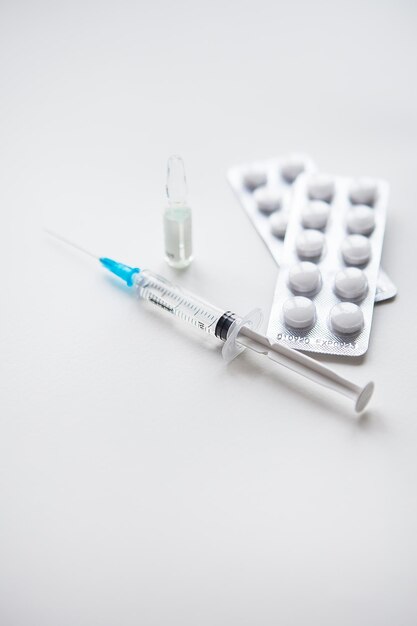Фото Подготовка к вакцинации против covid-19 шприцы вакцины таблетки медицинская маска на столе
