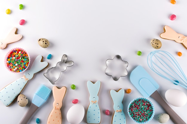 Preparation of gingerbread cookies. Easter cookies in the shape of  a  funny  rabbit , tools necessary to make gingerbread pastry, colored sprinkles. Easter concept.