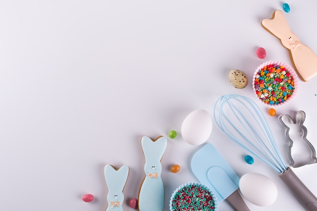 Preparation of gingerbread cookies. Easter cookies in the shape of  a  funny  rabbit , tools necessary to make gingerbread pastry, colored sprinkles. Easter concept.