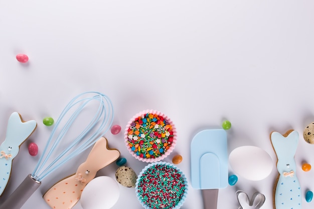 Preparation of gingerbread cookies. easter cookies in the shape of  a  funny  rabbit , tools necessary to make gingerbread pastry, colored sprinkles. easter concept.