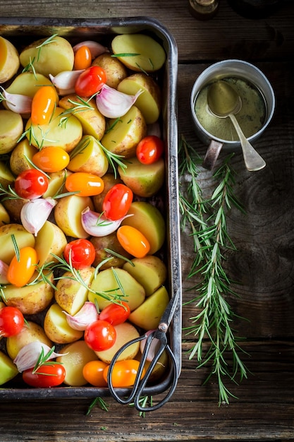 Preparation for grilled tasty potato with garlic rosemary and tomatoes