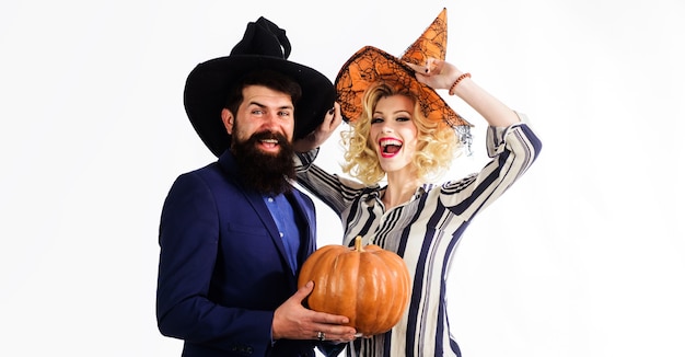 Preparation for Halloween. Happy couple in witches hats with pumpkin. Celebration and party concept. 31 october.