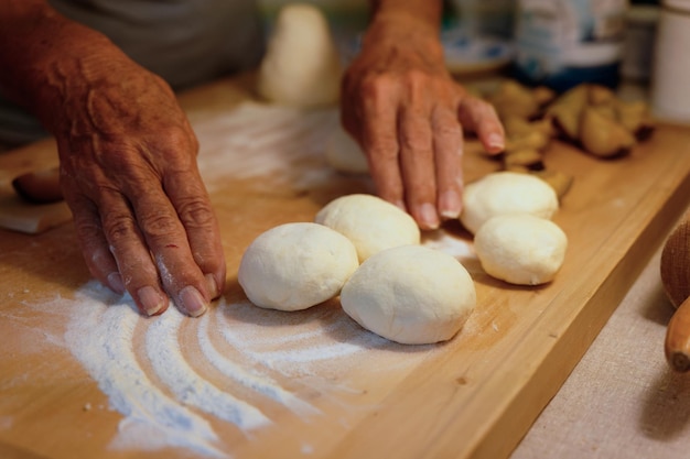 Photo preparation of homemade fruit dumplings with plums czech specialty of sweet good food dough on kitchen wooden table with hands