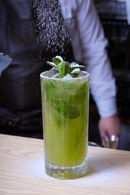 Preparation of a mojito cocktail by a bartender in a bar Summer fresh drink