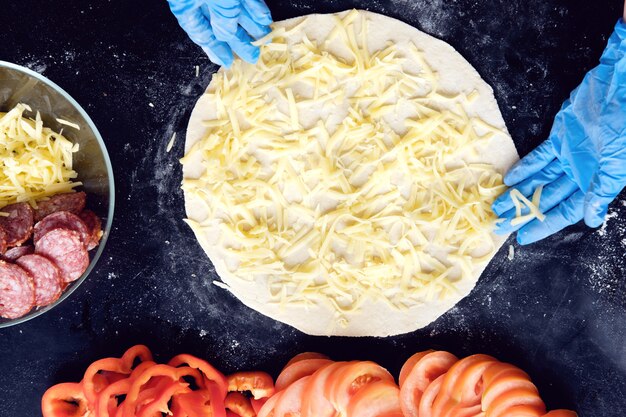 Preparation pizza in restaurant in silicone gloves, top view