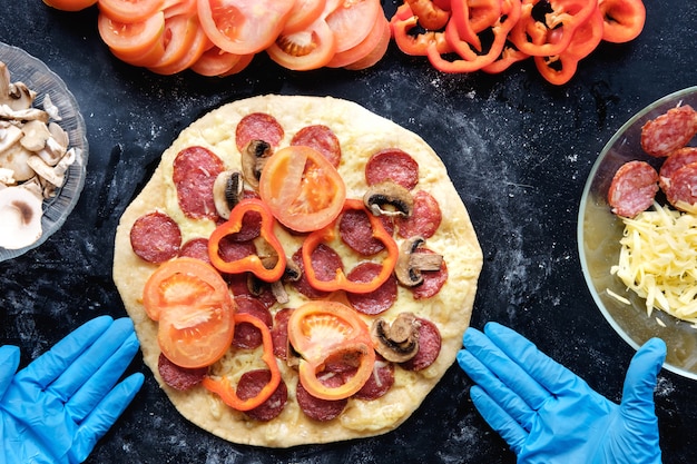 Preparation pizza in restaurant in silicone gloves, top view