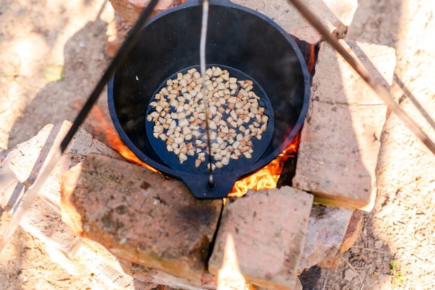 Preparation of raditional armenian pilaf in a cauldron on an open fire.