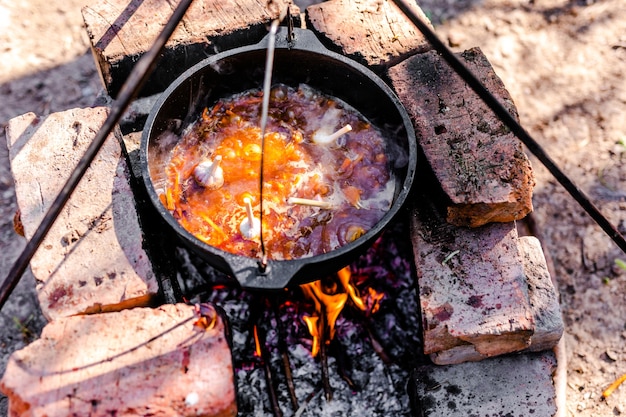 Preparation of raditional armenian pilaf in a cauldron on an open fire.