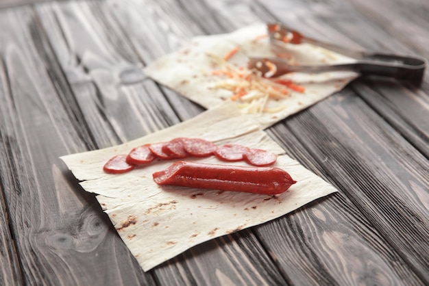 Preparation of salami in a pitaphoto on a wooden background