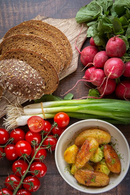 Preparation of summer sandwiches cottage cheese with green onions, radishes and tomatoes. keto diet ,Whole fried potatoes.healthy lifestyle.