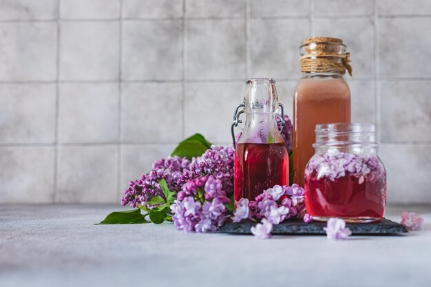 Photo preparation of syrup from the lilac flowers glass jar of homemade lilac syrup