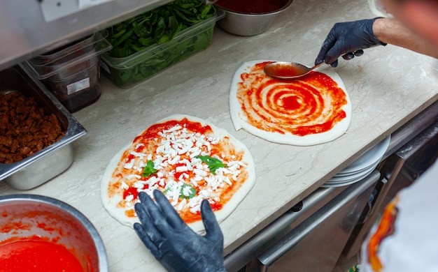 Preparation of traditional Neapolitan pizza with ingredients.