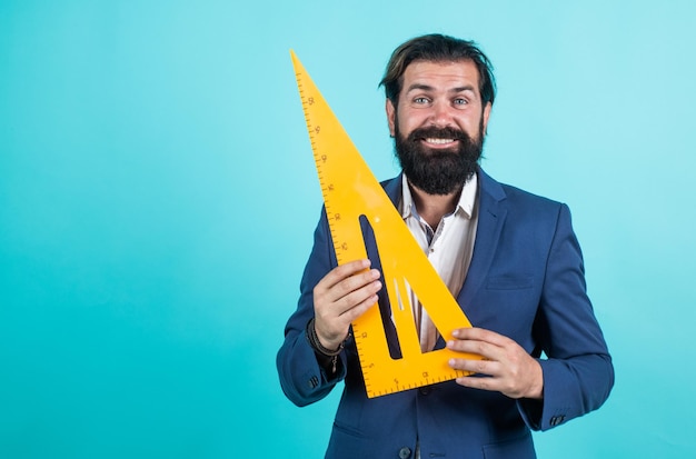 Prepare for geometry exam architecht or lecturer on math lesson
back to school formal education measure and size happy mature
teacher holding triangle tool bearded man engineer work with
ruler