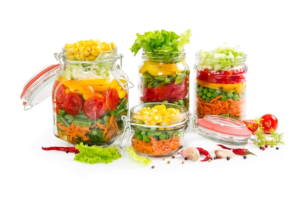 Prepared for canning colorful vegetables in glass jars isolated on white background