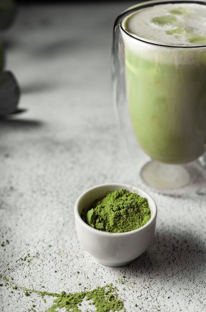 透明なグラスに抹茶を入れました。日本の緑茶粉末から作られたおいしい飲み物。垂直位置