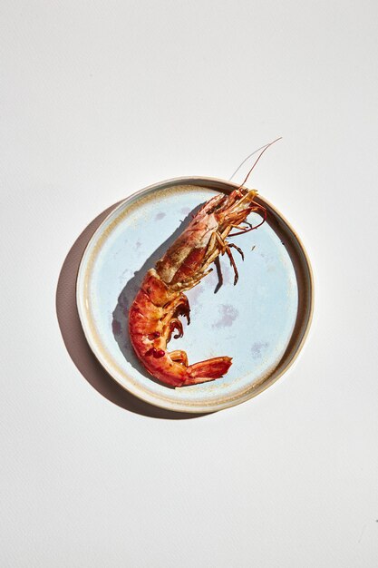 Prepared shrimps on plate on light background