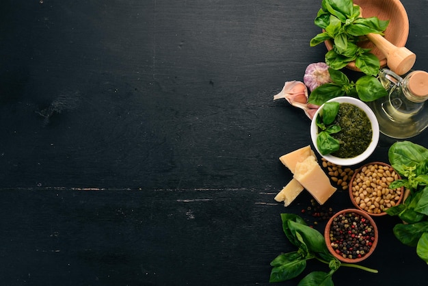 Preparing basil pesto sauce Basil parmesan cheese olive oil Top view On a black wooden background Free space for text