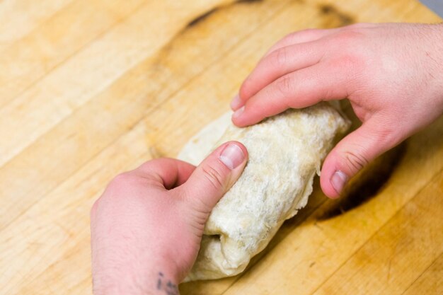 朝の食事のために朝食ブリトーを準備しています。