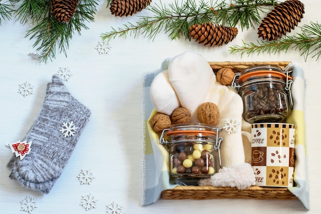 Photo preparing care package, handmade gift box with coffee beans, coffee cup, chocolate, warm socks