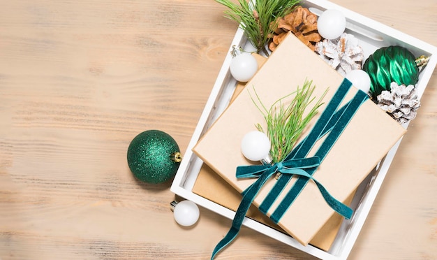 Preparing to celebrate Christmas or New Year. Gift box, christmas balls on wooden background