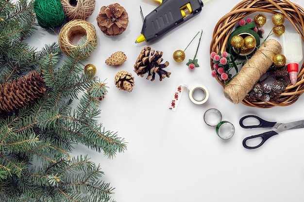 Preparazione per le vacanze di natale o capodanno flatlay di pelliccia rami di alberi ghirlande corda forbici artigianali...