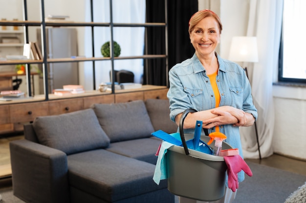 Preparing for cleaning. Resolute beaming lady spending day off at home and cleaning her space