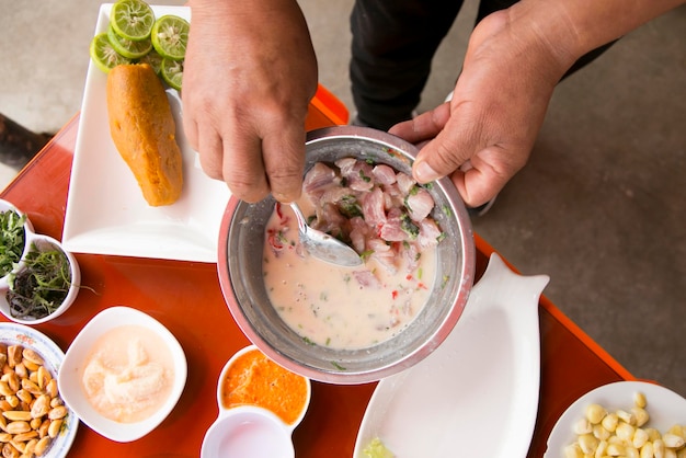 Preparing a delicious peruvian sea bass ceviche in the fishing port of chorrios in lima