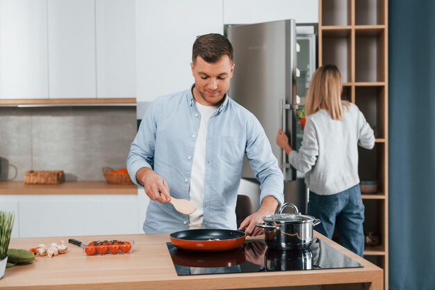 Preparing dinner couple at home on the modern kitchen