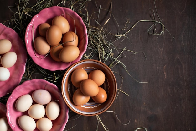 Preparing for Easter Chicken eggs in colorful plates on a wooden table