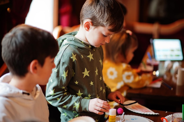 Preparazione al concetto di pasqua bambini che fanno a mano coniglietto e uova