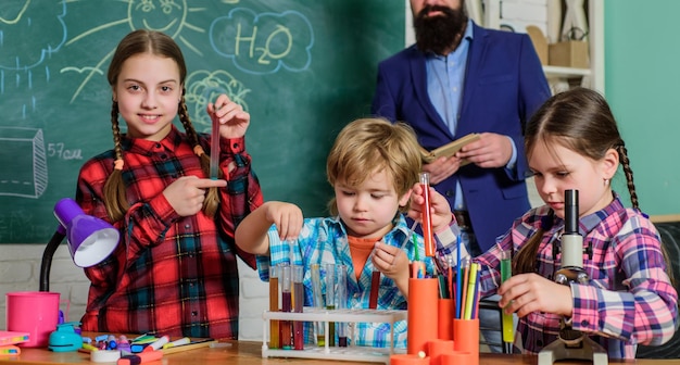 Preparing to exams children making science experiments Education Science and education chemistry lab happy children teacher back to school doing experiments with liquids in chemistry lab