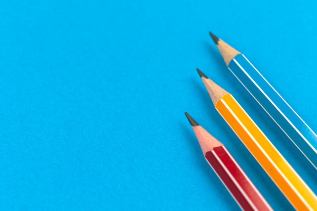 Preparing for the first days of school with simple lead pencils on flat lay blue background, copy space photo