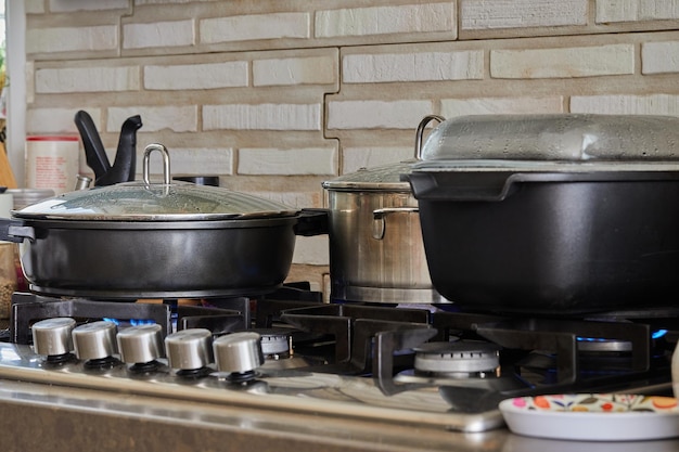 Preparing food in frying pan and casseroles on the gas stove in\
the kitchen home cooking concept