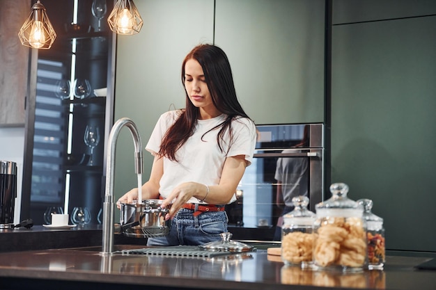 preparing fresh food young beautiful brunette in casual clothes indoors in kitchen at daytime