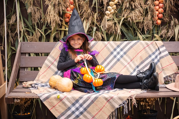 Preparing for Halloween A girl dressed as an evil witch dress and a big hat Shes in a good mood