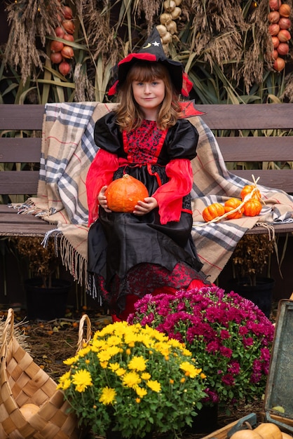 Preparing for Halloween A girl dressed as an evil witch dress and a big hat Shes in a good mood