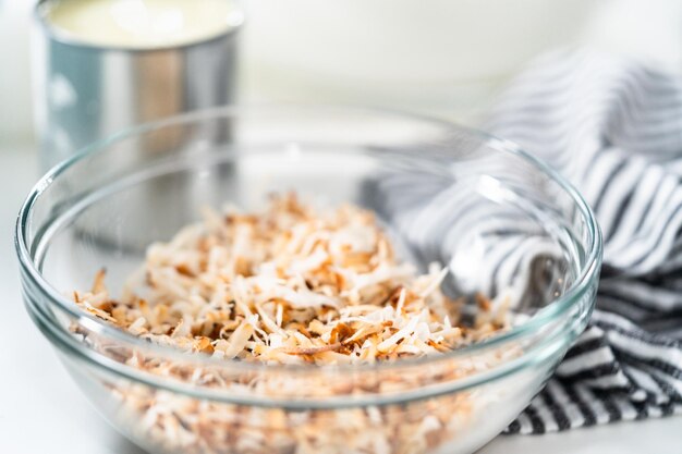 Preparing homemade coconut ice cream with roasted coconut flakes