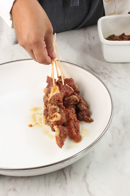 사진 idul adha 메뉴를 위한 수제 양고기 사테(sate kambing) 준비. sate kambing은 인도네시아에서 인기 있는 길거리 음식입니다. 컨셉 클린 키친