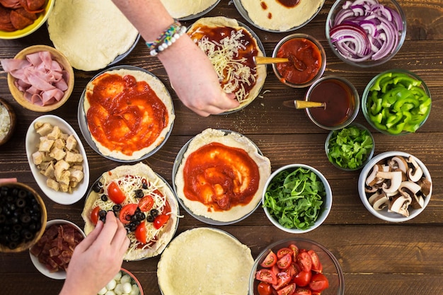 Preparing individual pizzas from pizza bar.