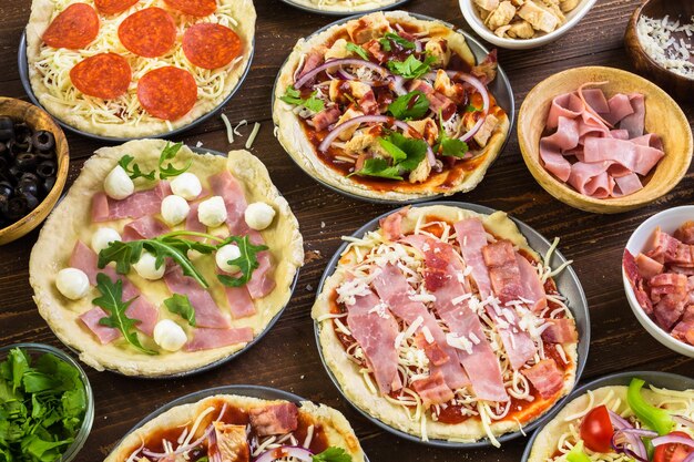 Preparing individual pizzas from pizza bar.