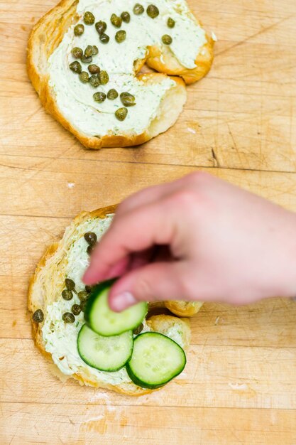 Preparing lox delight sandwich with fresh croissant.