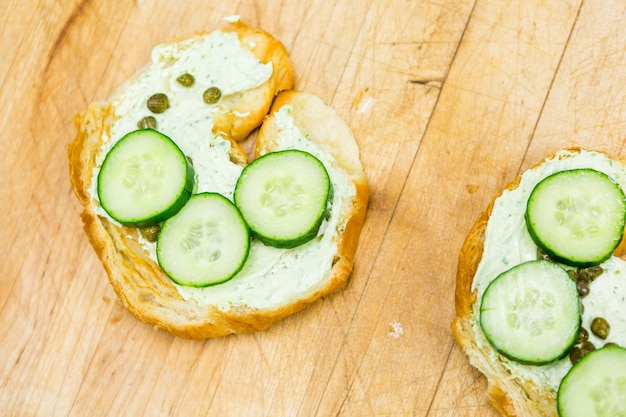 Preparazione del panino delizia lox con croissant fresco.