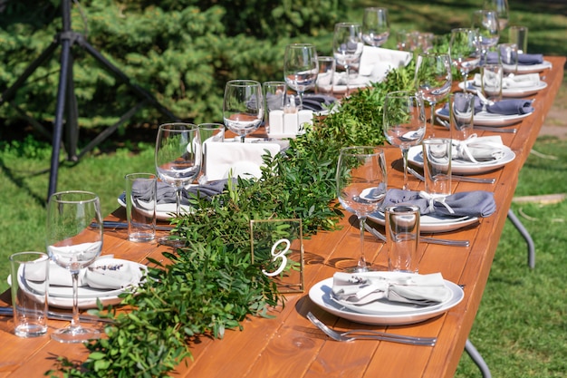 Preparing for an open-air party. Decorated with fresh flowers served tables. Table number. Decoration Details