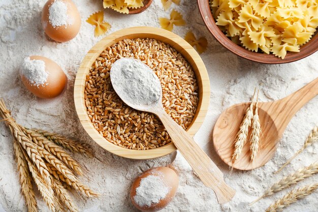 Preparing pasta with white flour and wheat on table closeup