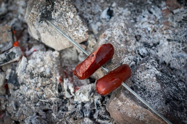 Preparing sausages on camp fire