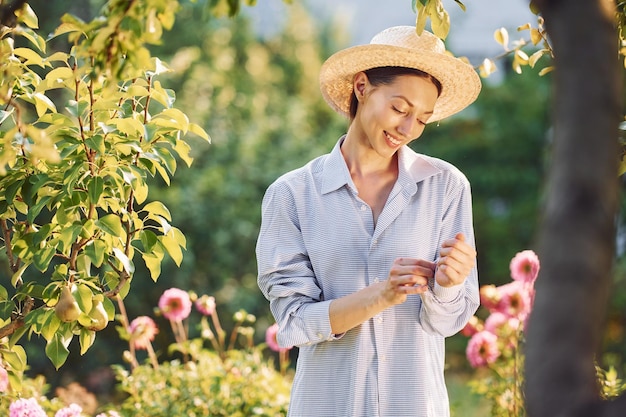 Preparing for a work Young cheerful woman is in the garden at daytime