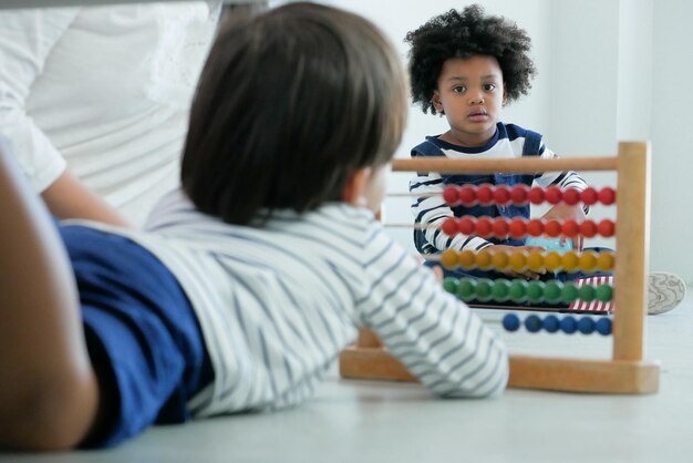 写真 幼稚園の男の子が学校で遊んでいる友達を見ている