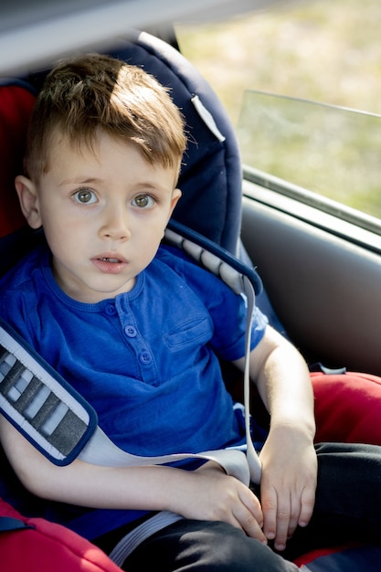 Preschool boy sitting in safety car seat