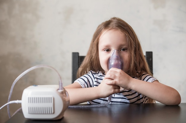 Una bambina in età prescolare durante un raffreddore fa inalazioni con un dispositivo